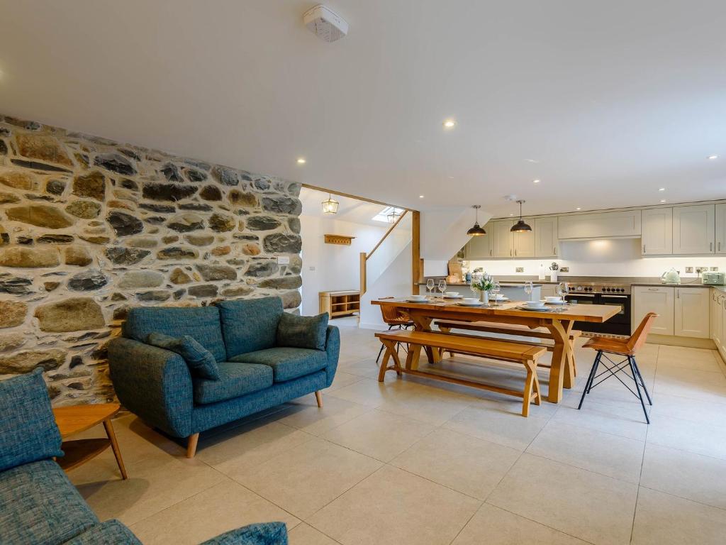 cocina y sala de estar con pared de piedra en 3 Bed in Aberdovey 75025, en Llwyngwril
