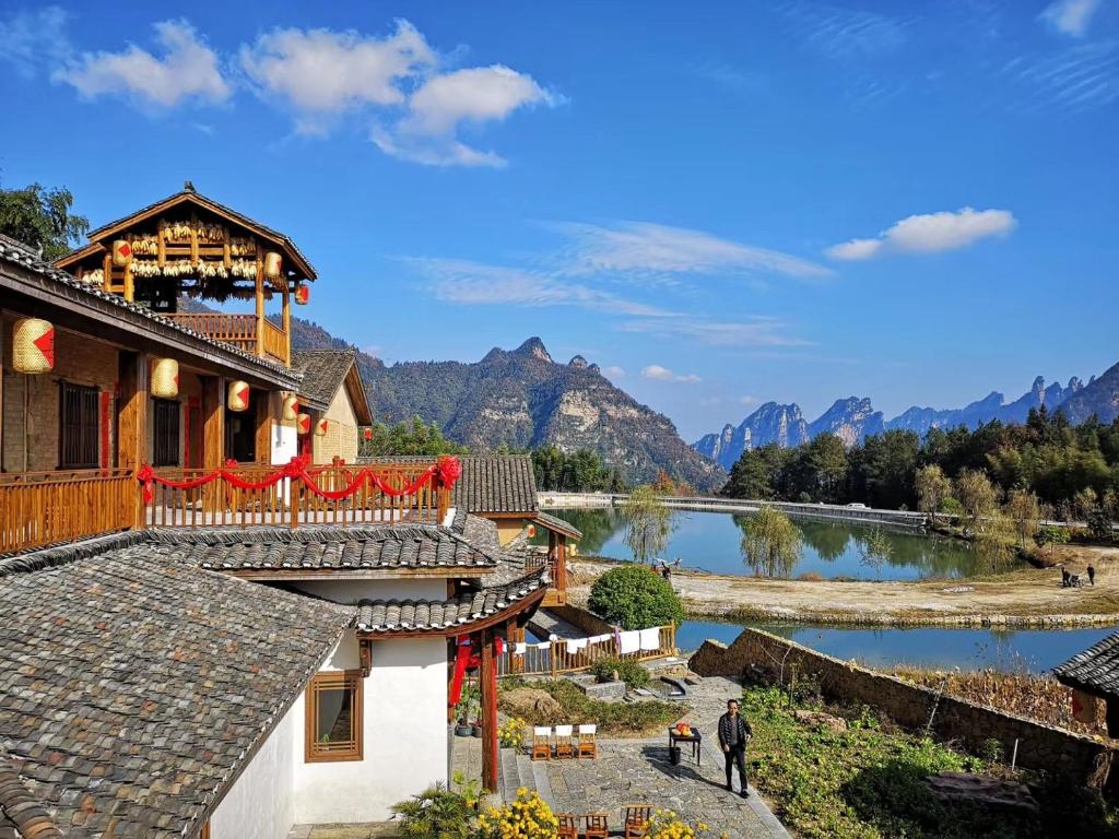 a building with a view of a river and mountains at Dayong Antique Feature Resort in Zhangjiajie