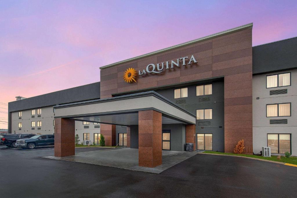 a hotel building with a sunitta sign on it at La Quinta by Wyndham Nashville Airport in Nashville