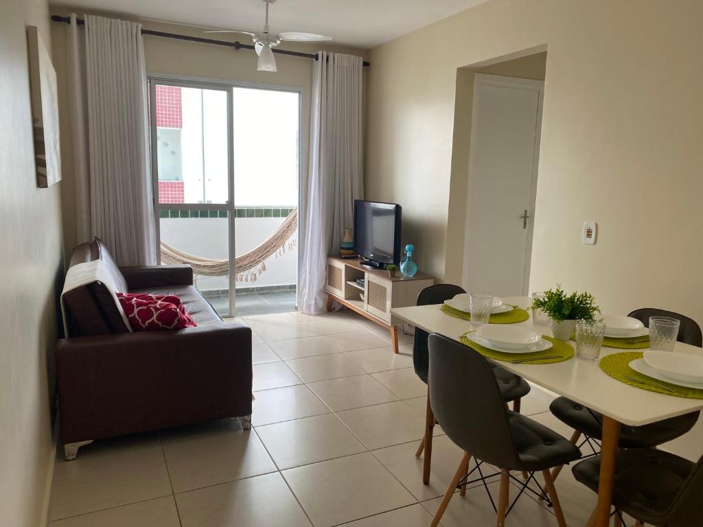 南灣的住宿－Ap aconchegante 12 min a pé p Praia，客厅配有桌椅和电视。