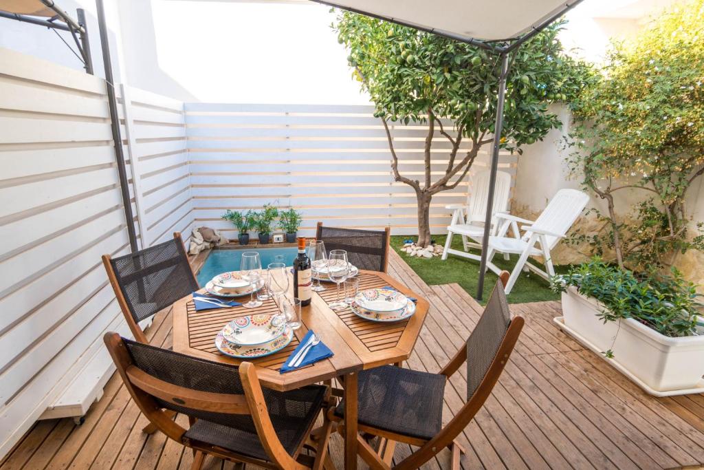 a patio with a wooden table and chairs on a deck at CapoSud - Suite Randa in Marina di Ragusa