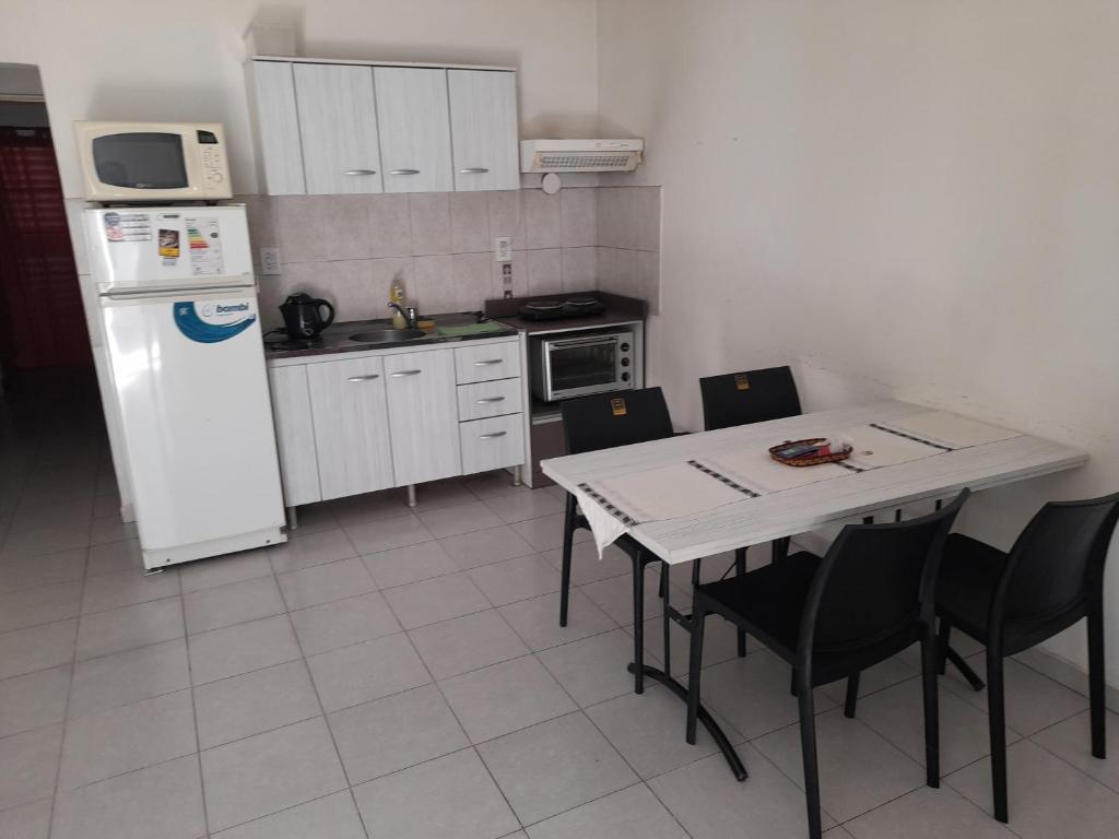 a kitchen with a table and a white refrigerator at Departamentos del Sol in Resistencia