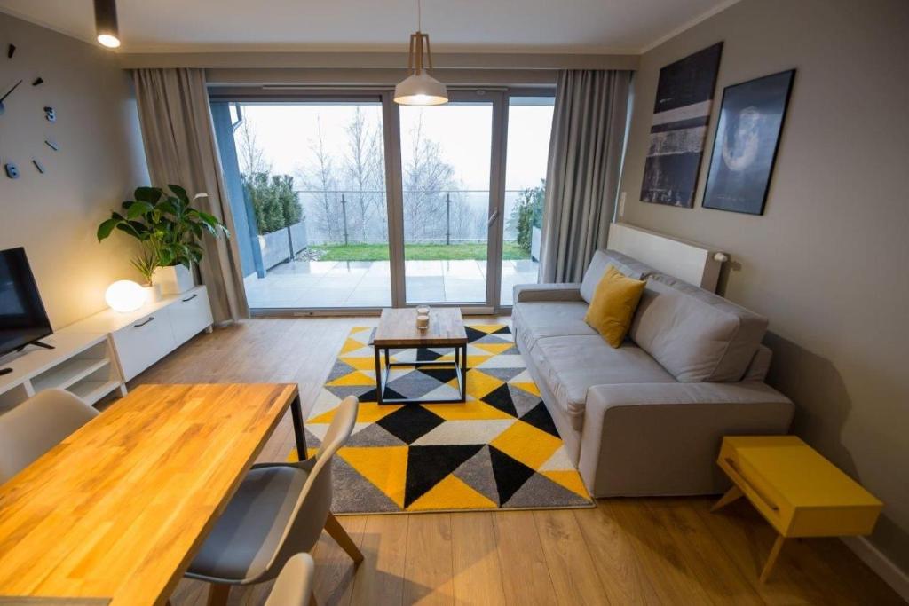 a living room with a couch and a table at VacationClub – Bukowa 17A Apartament E.2 in Wisła