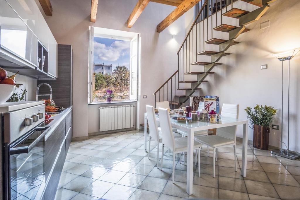 una cucina e una sala da pranzo con tavolo e scale di Amore Rentals - Appartamento Caruso a Sorrento