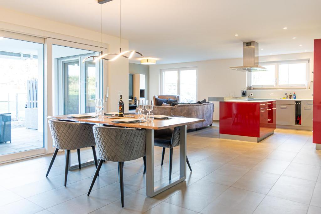 a kitchen and living room with a wooden table and chairs at Luxus 3,5 Zi-Whg 128m2, 8 Min zum See & Altstadt in Stein am Rhein