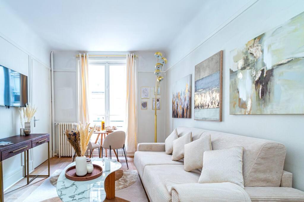 un salon avec un canapé et une table dans l'établissement Charmant Appartement au Cœur de Neuilly-sur-Seine, à Neuilly-sur-Seine