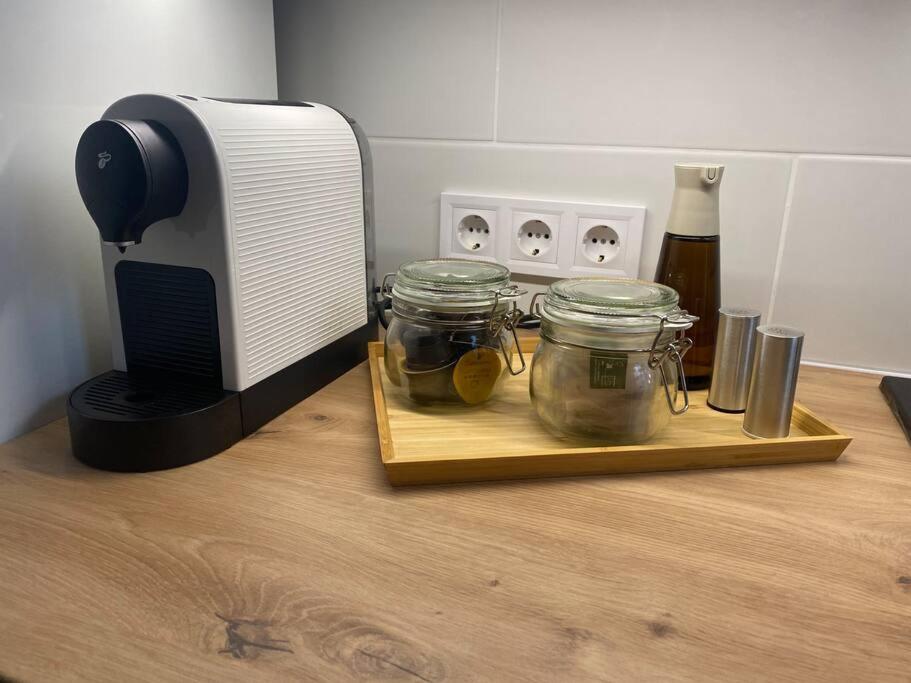a counter with two jars on a cutting board next to a toaster at Maros Apartman in Budapest