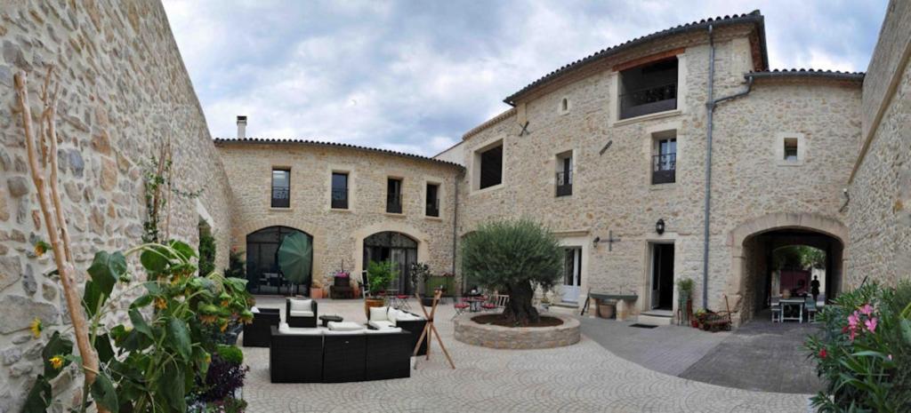 a courtyard in a stone building with couches and chairs at L'Escampe in Saturargues