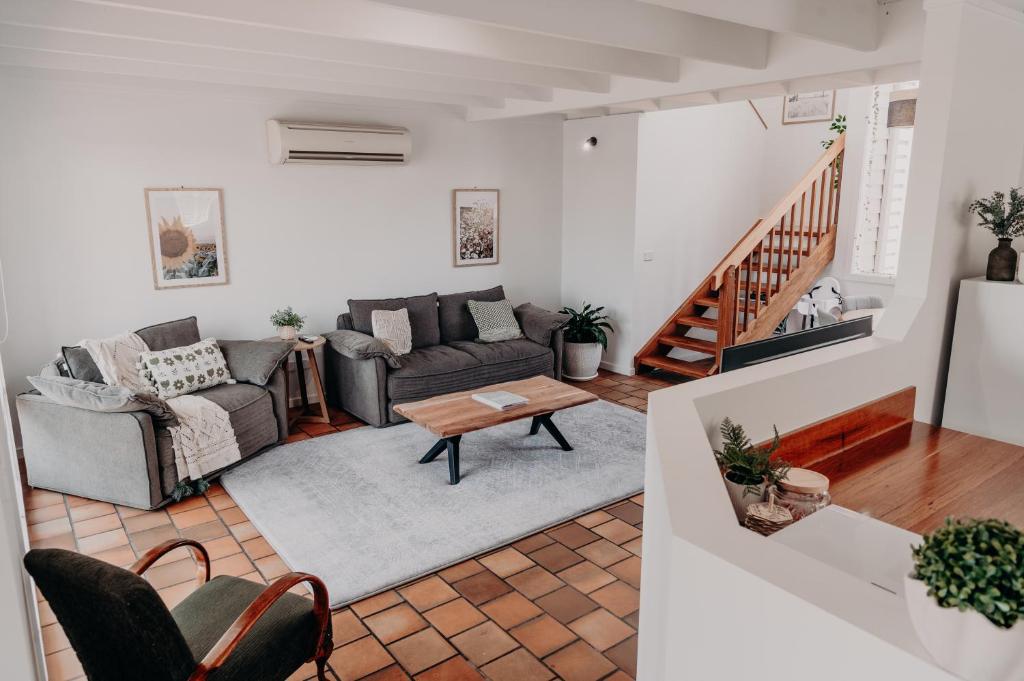 a living room with two couches and a table at The Sage Cottage - Explore Bendigo CBD on foot! in Bendigo