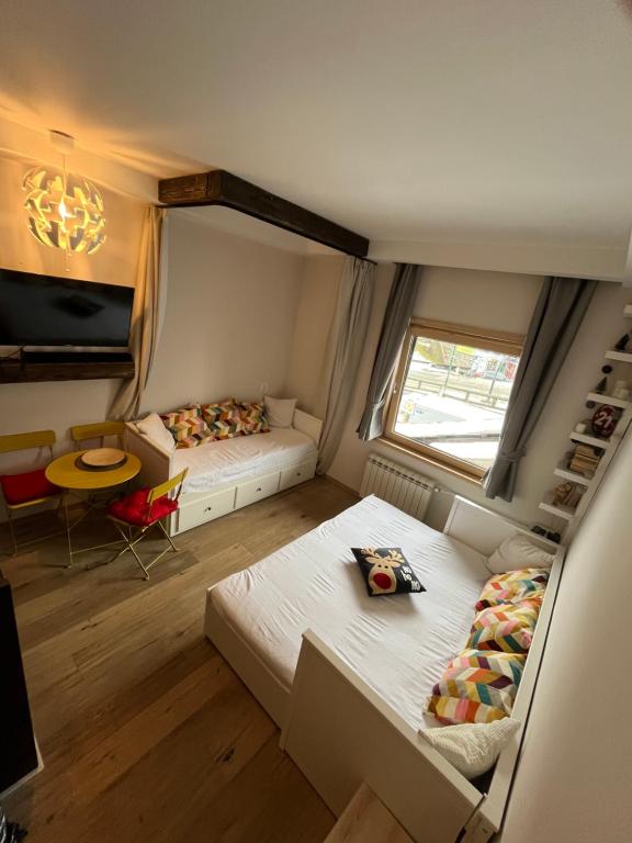 a small room with two beds and a window at Apartman Brvenik 103, Konaci, Kopaonik in Kopaonik