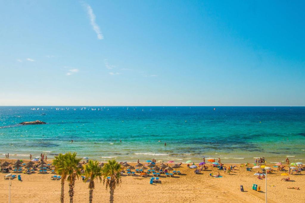 a group of people on a beach with the ocean at Apartamento Calpeplaya - PlusHolidays in Calpe