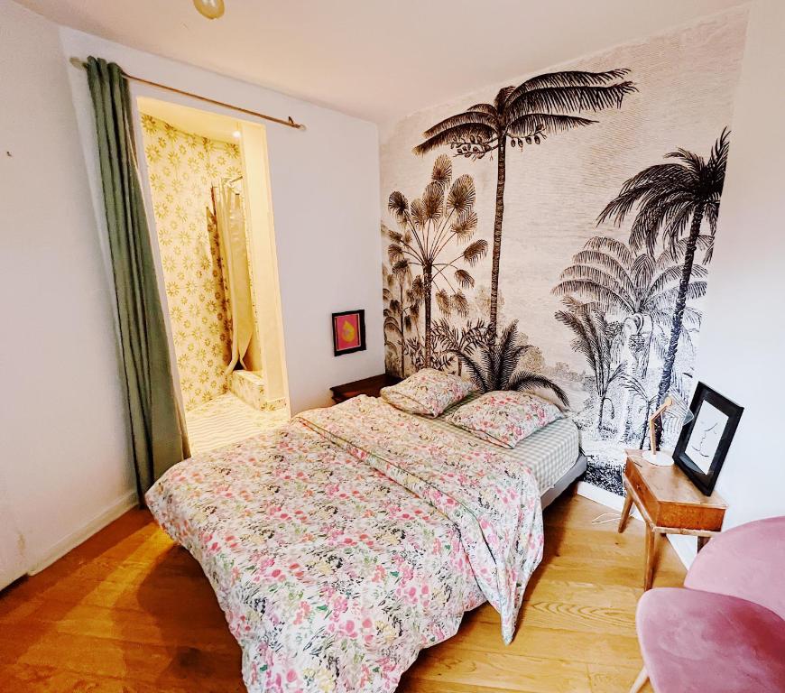 a bedroom with a bed and palm trees on the wall at Chambre confortable chez particulier avec salle de bain privée in Nantes