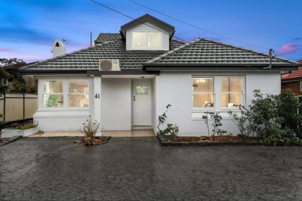 une maison blanche avec un toit dans l'établissement Delightful Home with Amazing city views!, à Sydney