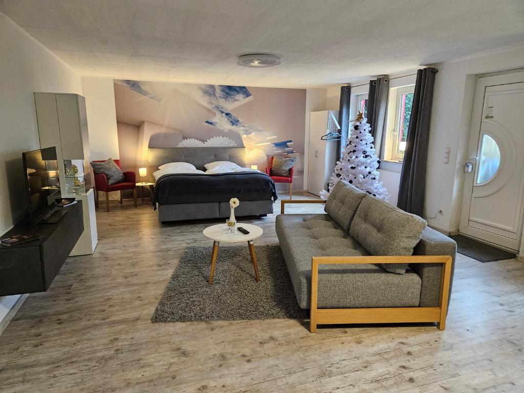 a living room with a christmas tree and a bed at Garden-Loft in Stadelhofen