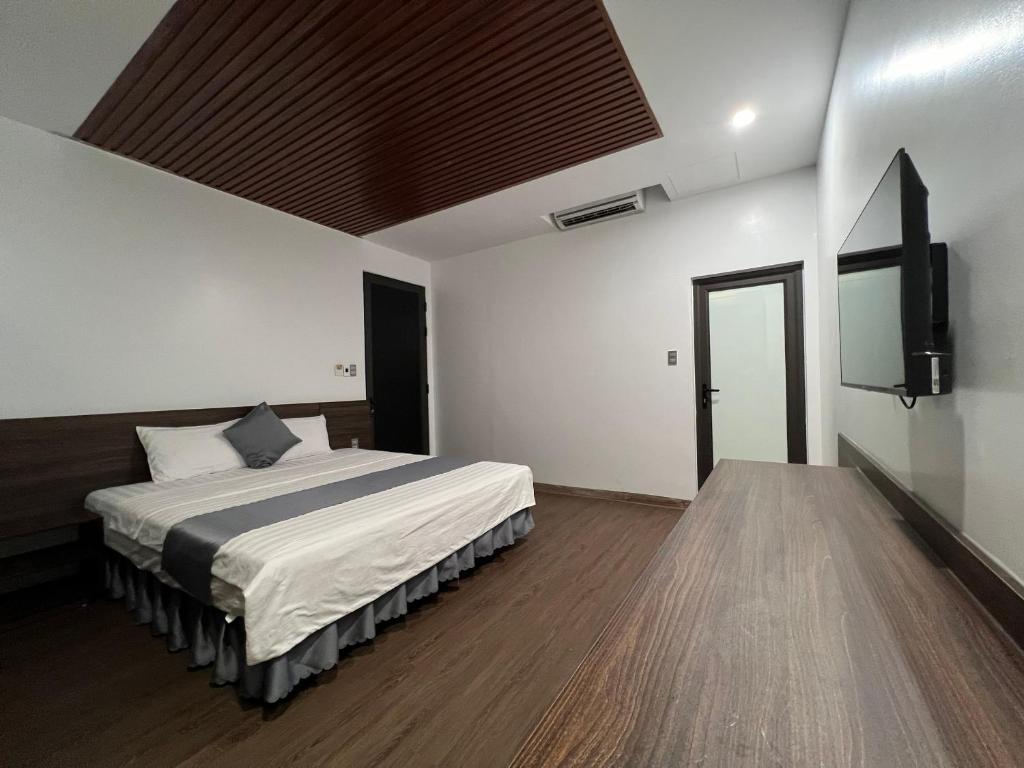 um quarto com uma cama e uma televisão de ecrã plano em Happy House Moc Chau em Mộc Châu