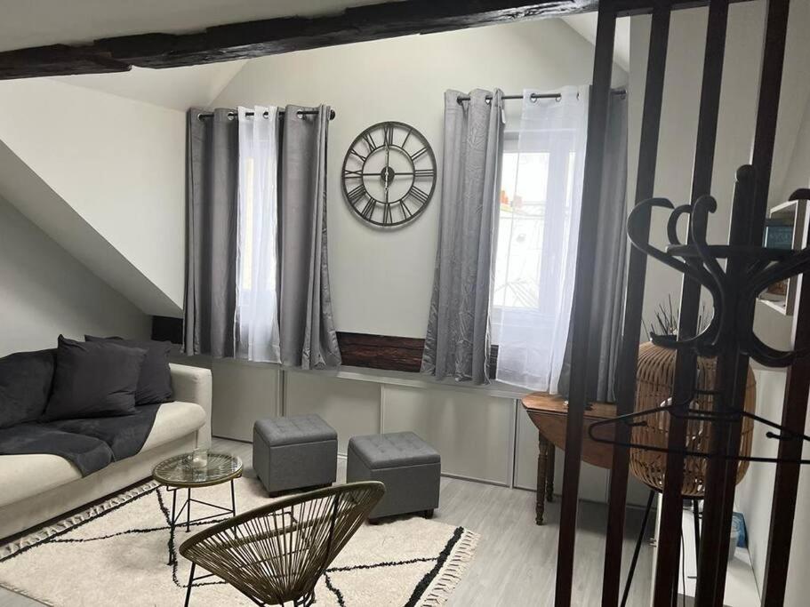 un salon avec un canapé et une horloge au mur dans l'établissement Ile Saint Louis, à Paris