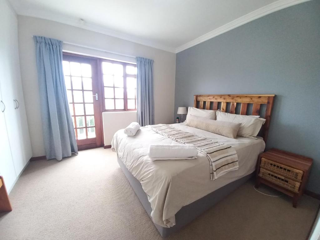 Un dormitorio con una cama grande y una ventana en Modern two bedroom apartment., en Port Alfred
