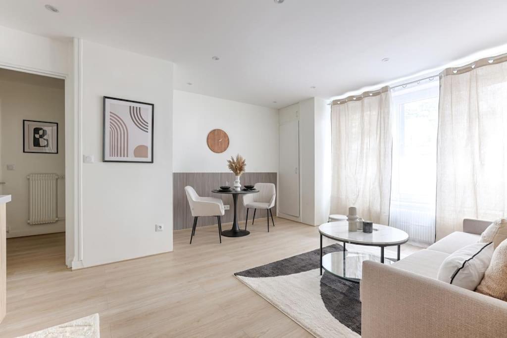 a white living room with a couch and a table at Magnifique Studio Clichy in Clichy