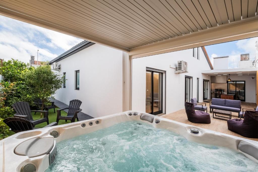 an indoor hot tub in a house with a patio at Azores Top House // Luxury and New House in Ponta Delgada