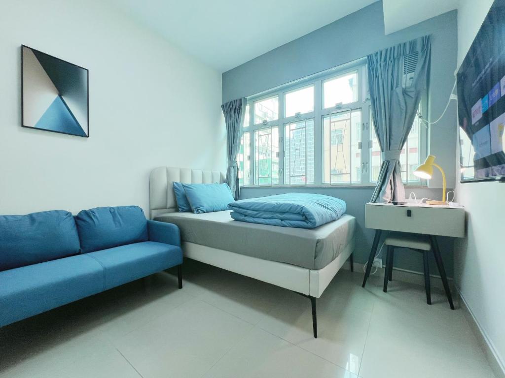 a bedroom with a bed and a couch and a window at Student Accommodation - 26 Man Yuen Street in Hong Kong