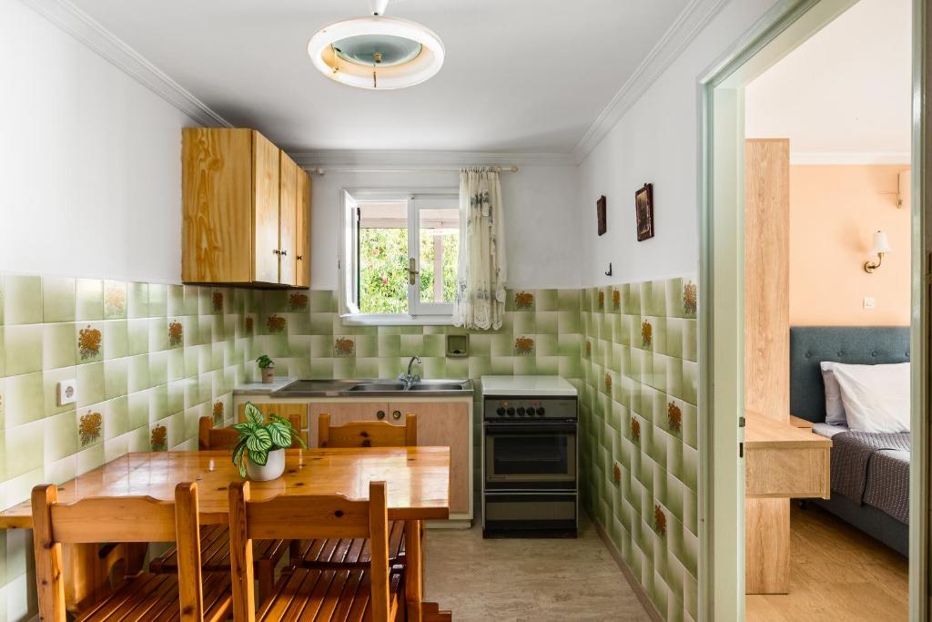 a kitchen with a wooden table and a dining room at Marietta's Resort by Konnect, Gouvia Corfu in Gouvia
