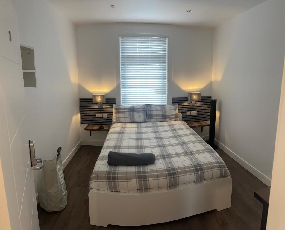 a bedroom with a bed with a plaid blanket at Woodburn, Falkirk in Falkirk