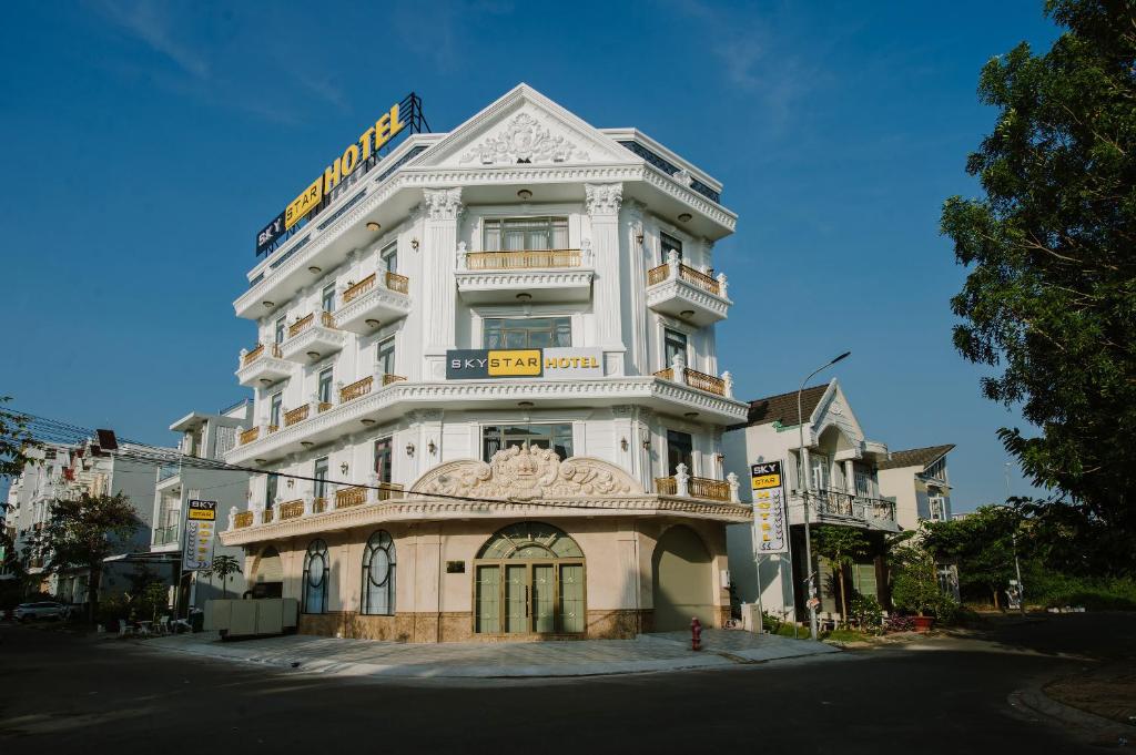 ein hohes weißes Gebäude an der Ecke einer Straße in der Unterkunft Sky Star Hotel in Cần Thơ