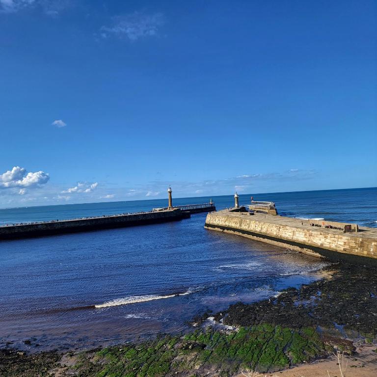 a pier stretches out into the ocean on a clear day at Victoria Cottage in Whitby
