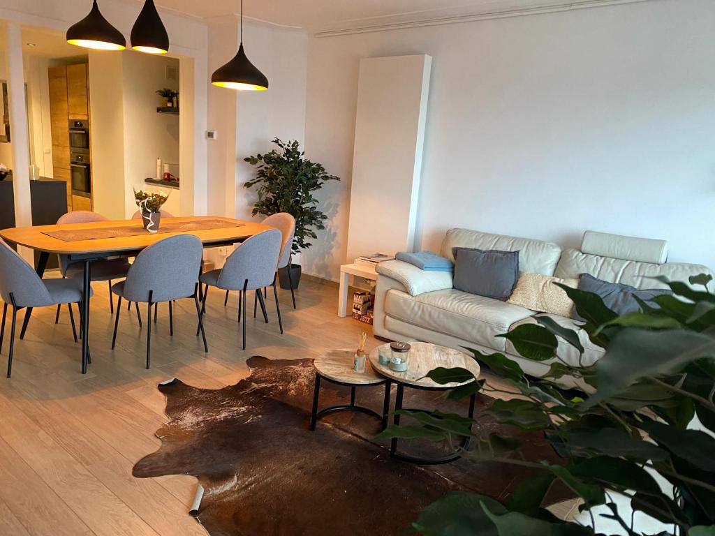 een woonkamer met een tafel en een bank bij Spacious Apartment With Sea View in Oostende