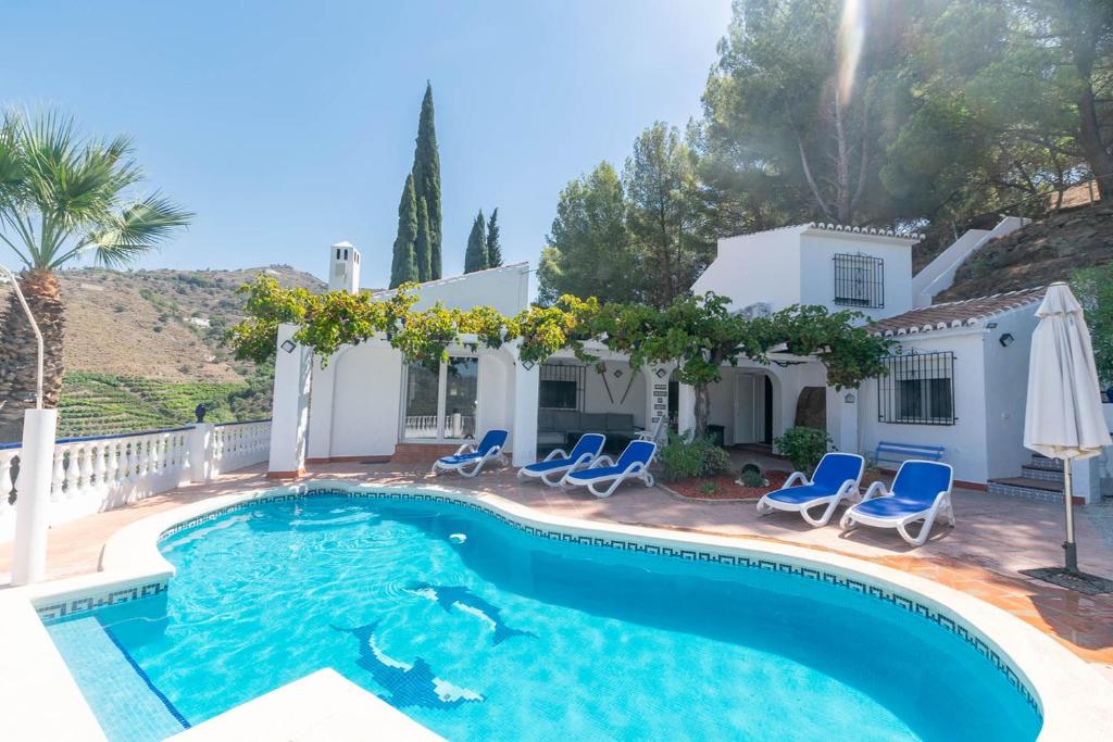 ein Swimmingpool mit Stühlen und ein Haus in der Unterkunft Casa Chatsee in Torrox