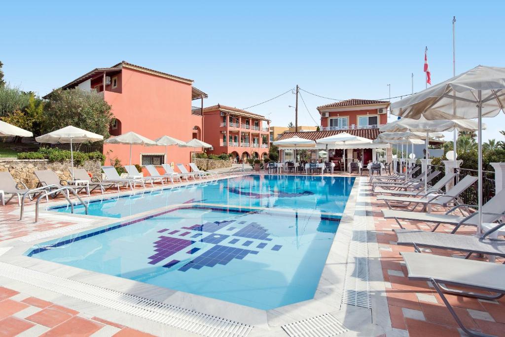 a large swimming pool with chairs and umbrellas at Marietta's Resort by Konnect, Gouvia Corfu in Gouvia