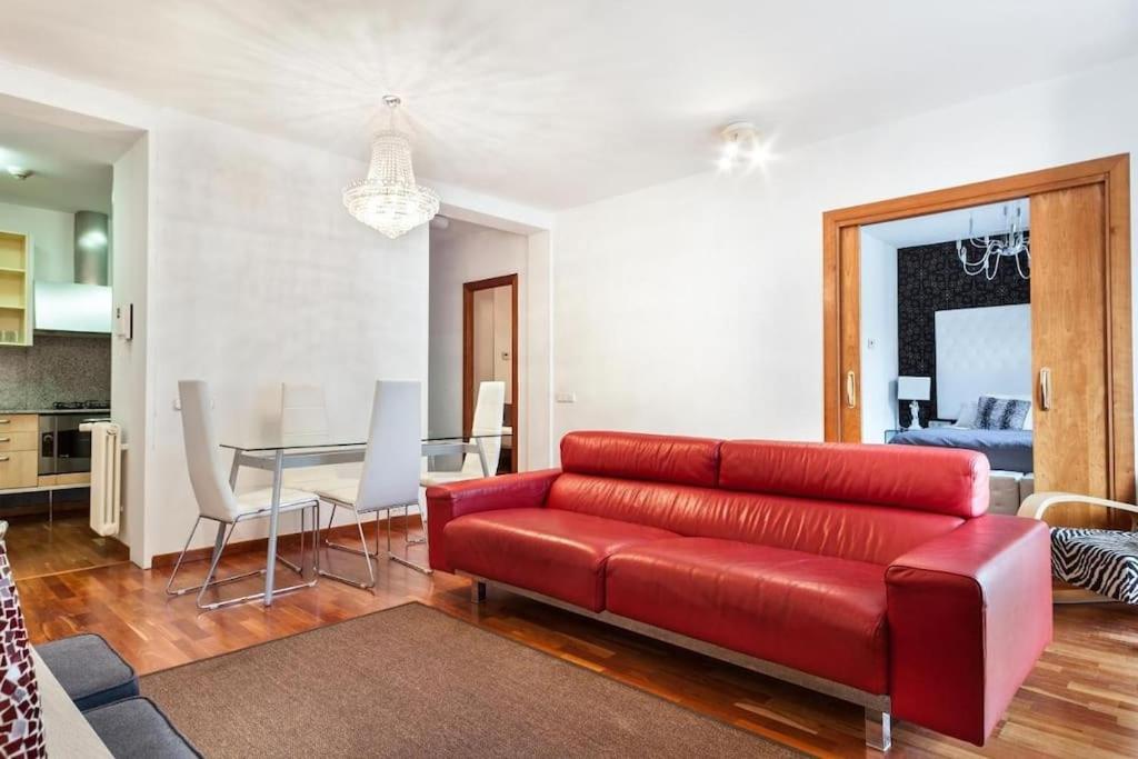 a living room with a red couch and a table at Canela Homes BARCELONA UNIVERSITAT in Barcelona