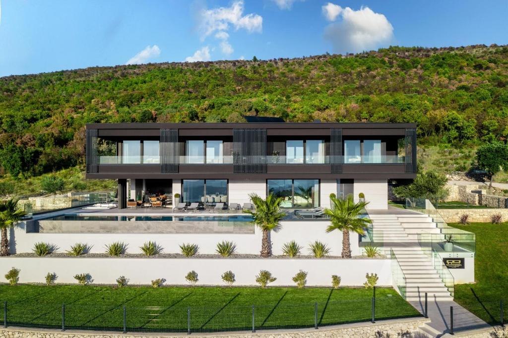an image of a house with a hill in the background at Luxury Exclusive Villa Panoramica near Labin - Rabac only 2 km from the beach with sea view and wellness in Koromačno