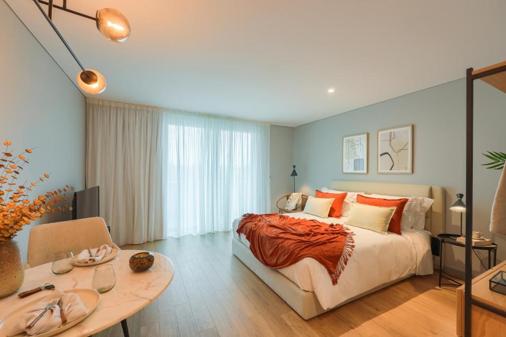 um quarto com uma cama grande e uma mesa em Icon Apartments by NÔMA no Porto