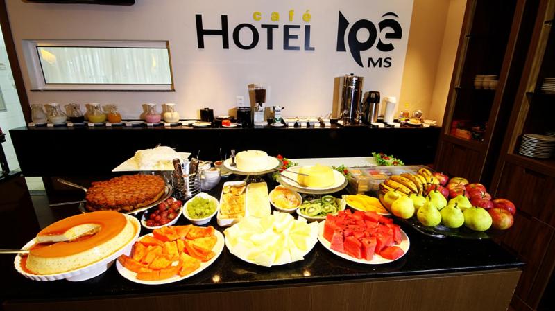 um buffet com muitos tipos diferentes de comida em um balcão em Hotel Ipê MS em Campo Grande