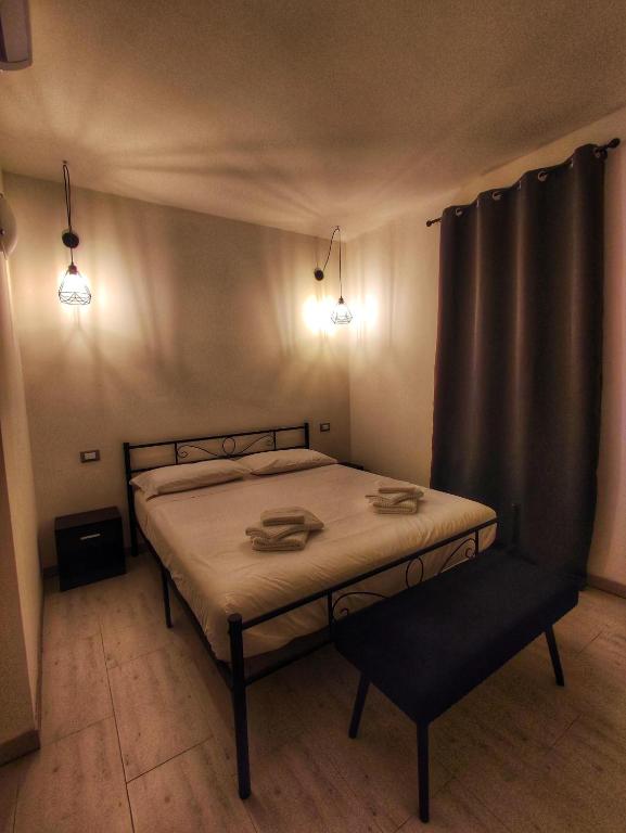 a bedroom with a bed with a chair and lights at Foresteria Del Borgo Etrusco in Lonato
