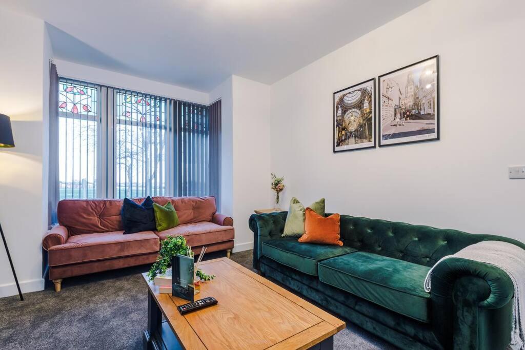 a living room with two green couches and a table at Beautiful Bradford Home Sleeps 8 with Parking by PureStay Short Lets in Wibsey