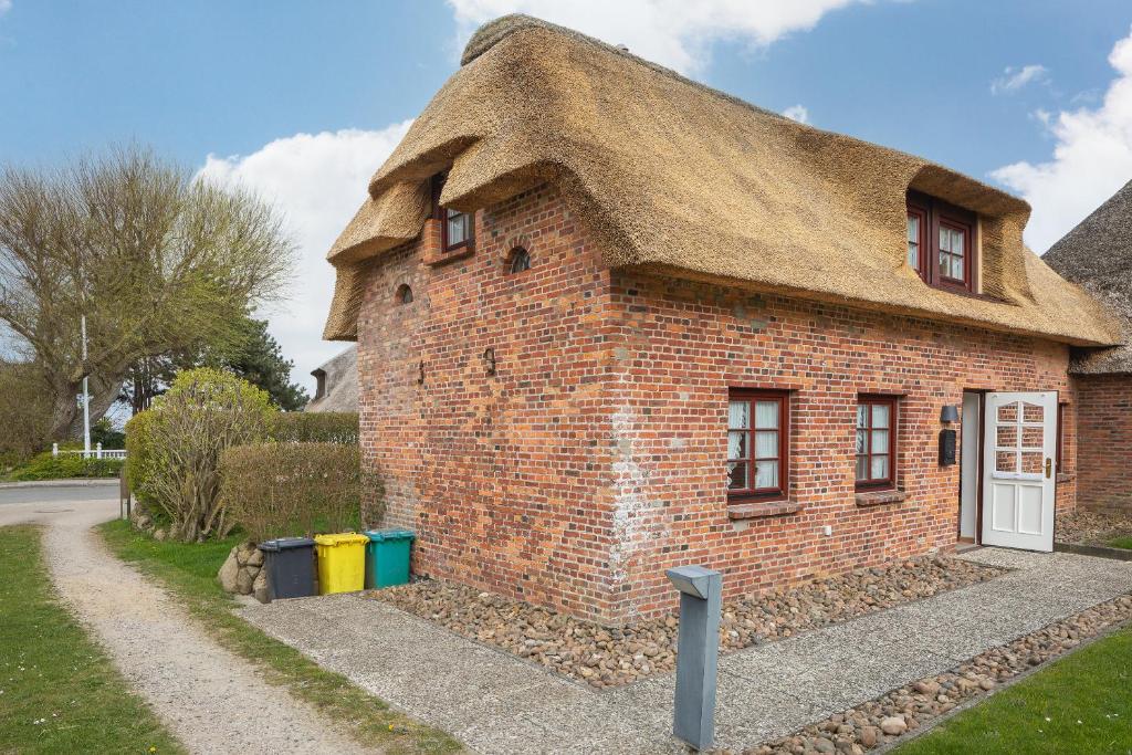 a small brick building with a thatched roof at Kleine Kate in Keitum