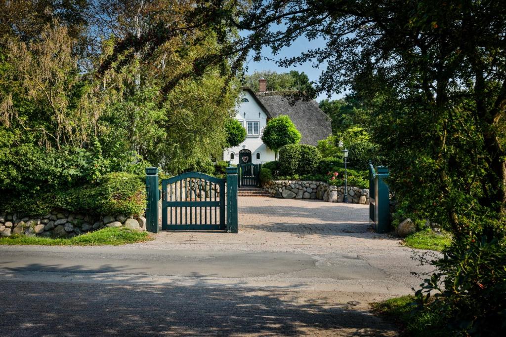 a gate in front of a white house at Daluja in Keitum