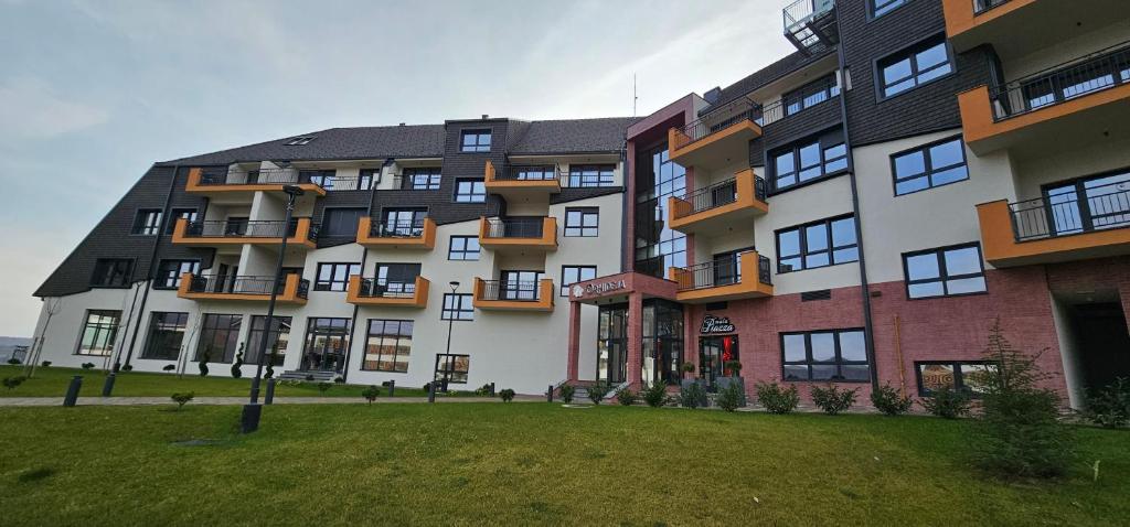 ein großes Apartmenthaus mit Rasen davor in der Unterkunft Fruske rezidence A204 in Vrdnik