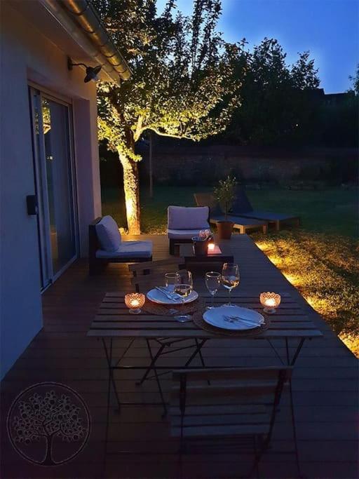 a patio with a table and chairs on a porch at Guest house avec spa Jura , gîte du petit pommier 