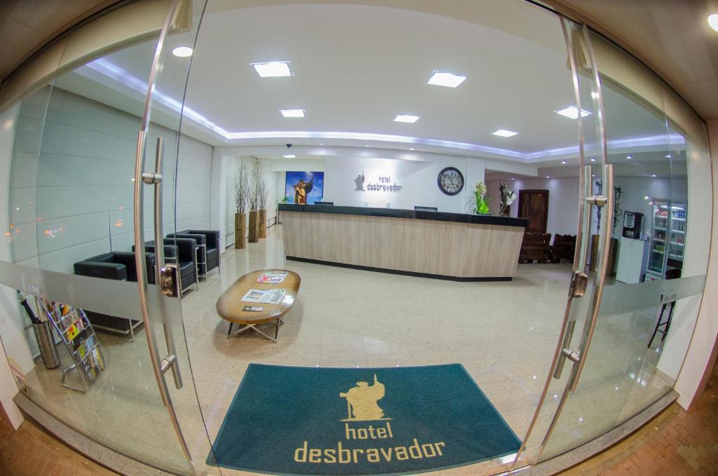 a glass window of a hospital lobby with a reception desk at Hotel Desbravador in Chapecó