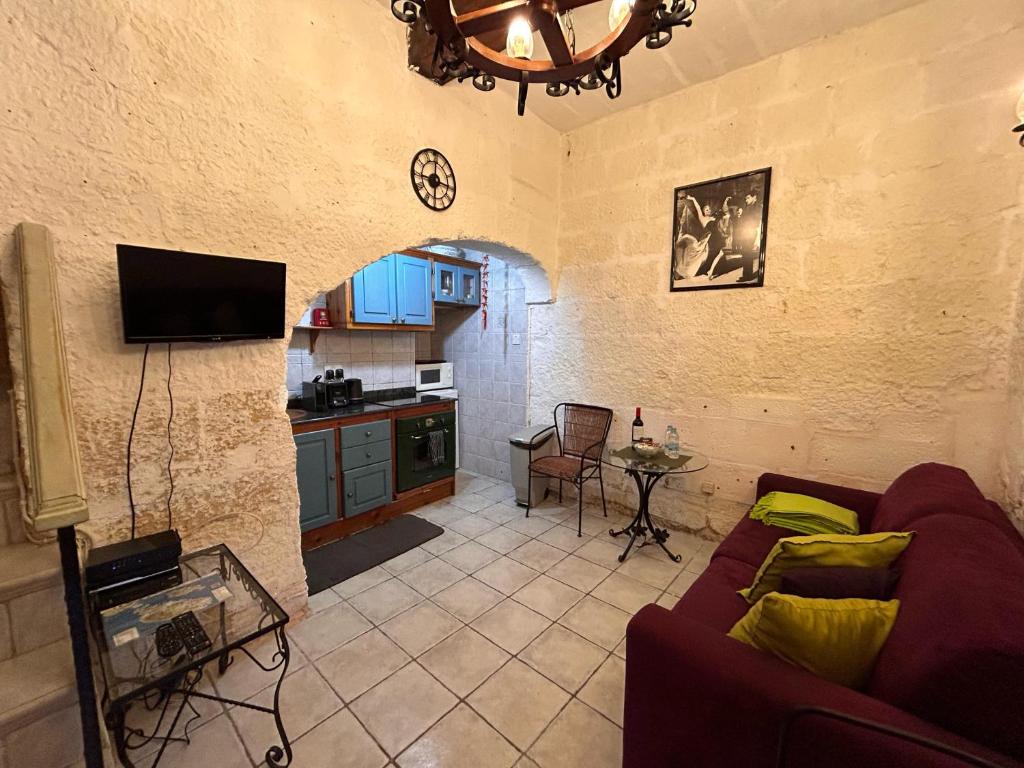 sala de estar con sofá y cocina en Central Valletta Townhouse with Maltese Balcony en La Valeta