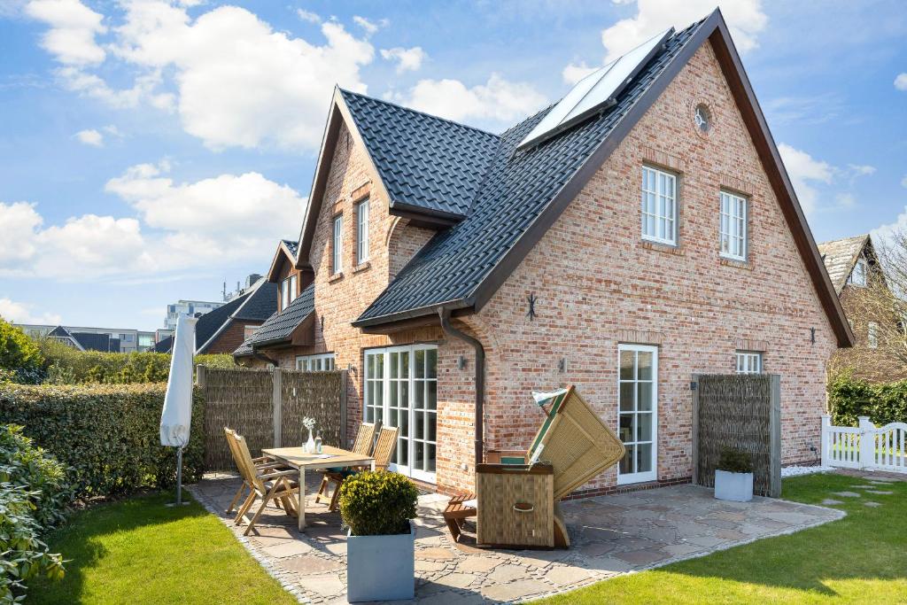 a brick house with a patio and a table at Gode Tiet in Westerland