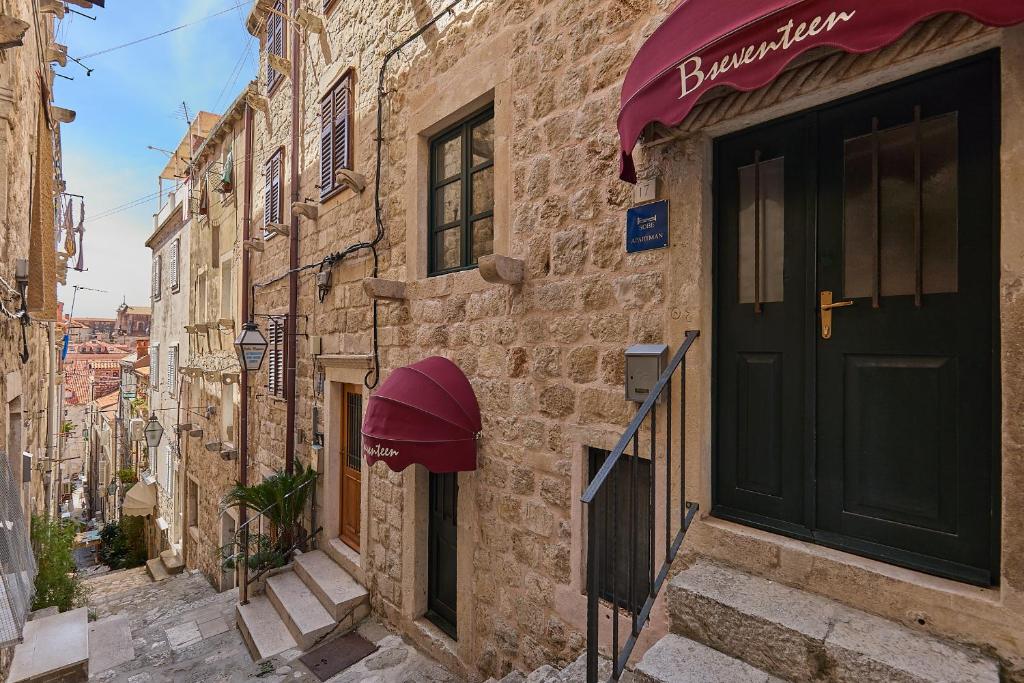 a building with a black door and a red awning at B18 APARTMENT in Dubrovnik