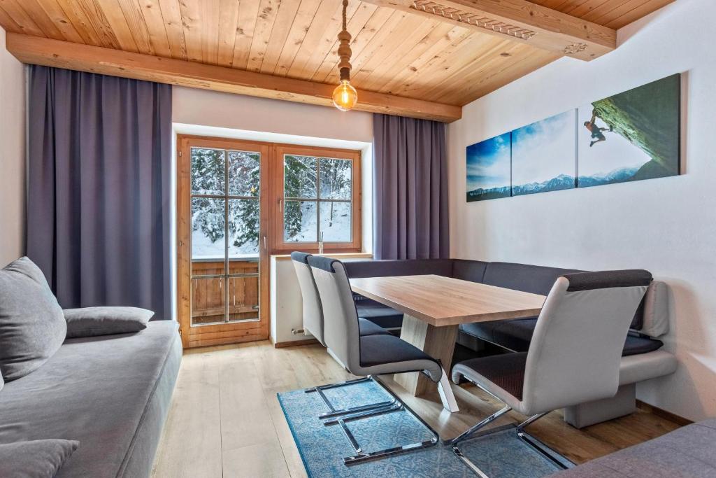 uma sala de jantar com uma mesa de madeira e cadeiras em Schwüwong - Apartment 12 em Kelchsau
