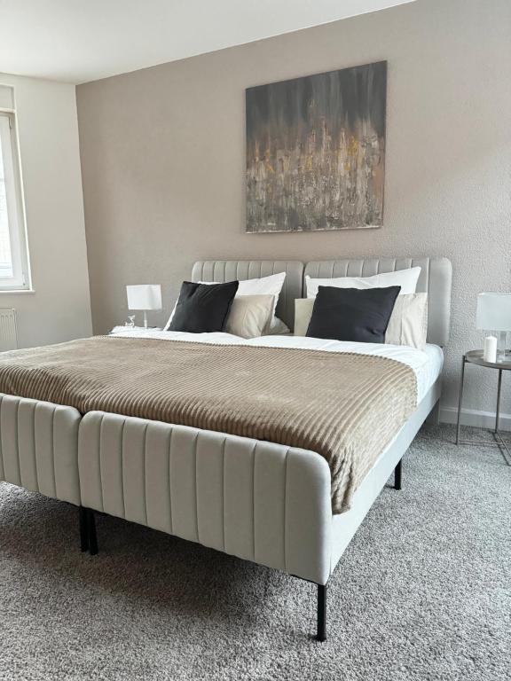 1 cama blanca grande en un dormitorio con 2 lámparas en Haus Gitta II, en Luckenwalde