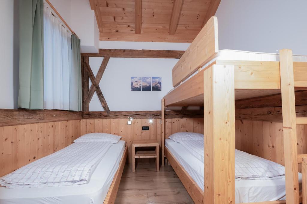 2 Etagenbetten in einem Zimmer mit einem Schreibtisch in der Unterkunft Rifugio La Para in St. Vigil