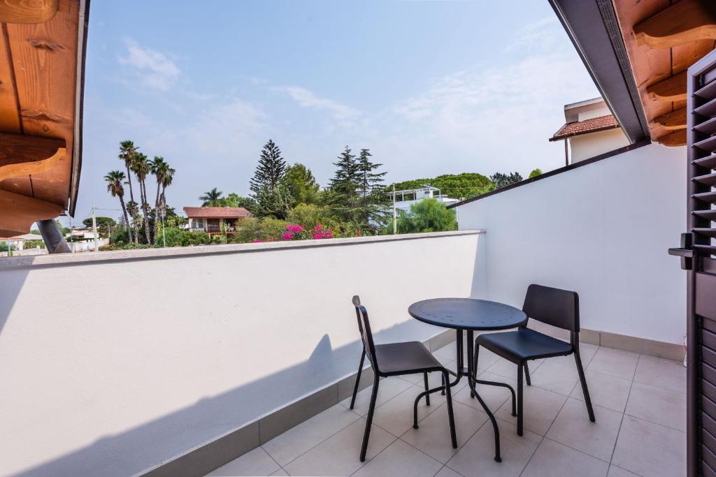 a table and two chairs on a balcony with a view at Casa nel Verde a Fontane Bianche by Wonderful Italy in Siracusa