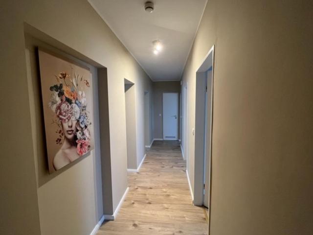 a hallway with a painting on the wall at Secrets Design Apartment in Rodenbach
